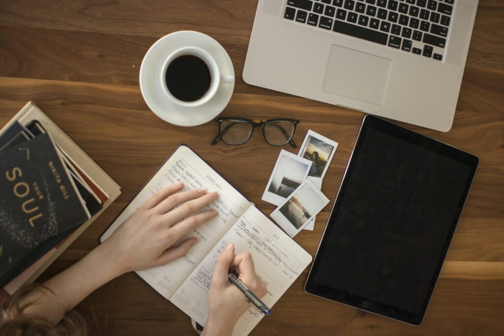 Arbeitsplatz mit Notizbuch, Laptop und Tablet für die Datenanalyse im Controlling