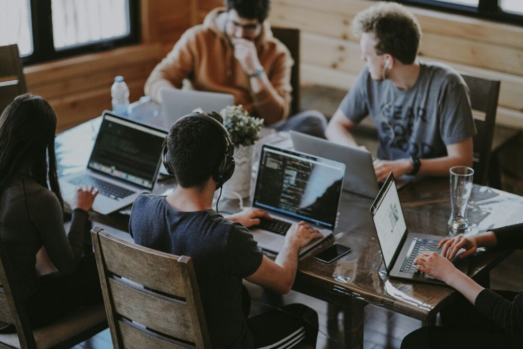 Team arbeitet gemeinsam an einem Tisch mit Laptops
