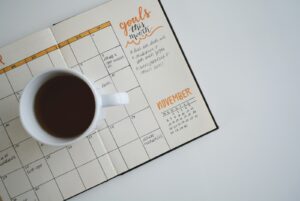 Kalender und Kaffeetasse auf einem Tisch